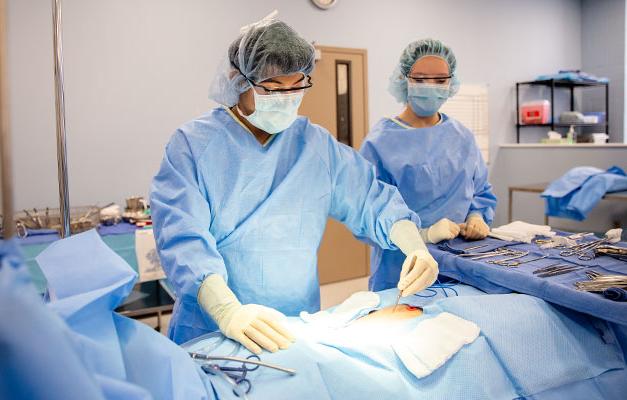 Surgical Technician Students Practicing on a Mannequin for a Test. 